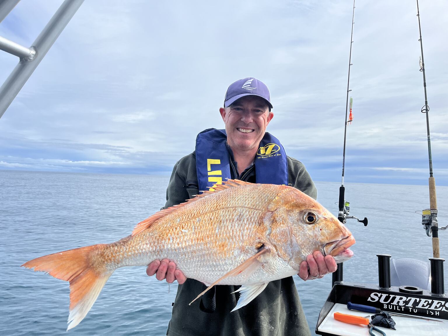 Paul holding a large snapper on a boat